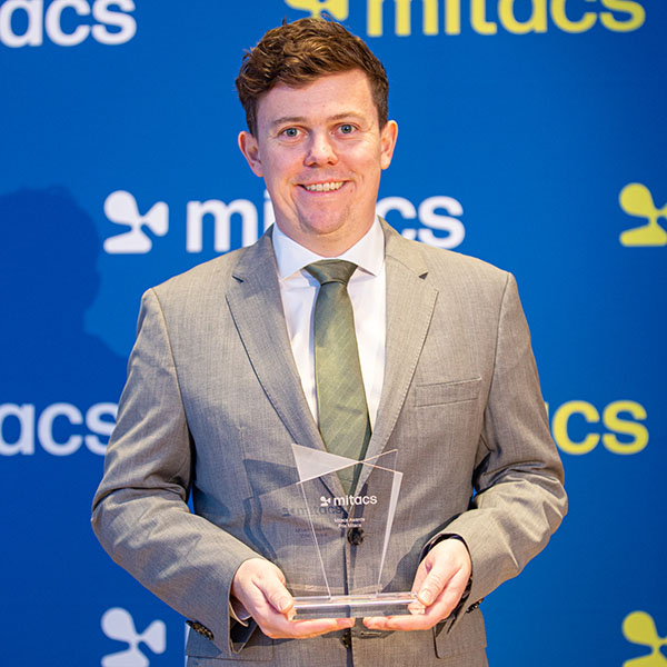 Matthew Mitchell holding award